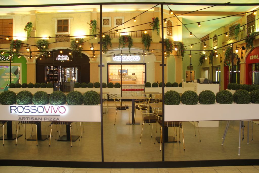 Entrance of Rossovivo Mercato Mall. Staineg glass walls on the foreground.